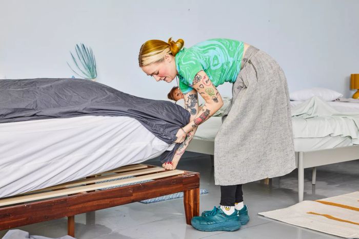 A person making the bed with the Sijo Home Organic Percale Cotton CrispCool Sheet Set
