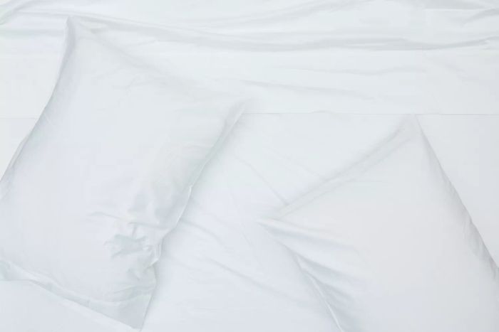 White Boll & Branch Signature Hemmed Sheet Set paired with pillows on a bed