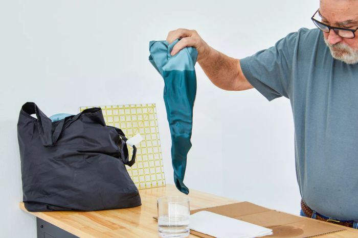 Person dipping a Colorado Home Co. Mulberry Silk pillowcase into a glass of water