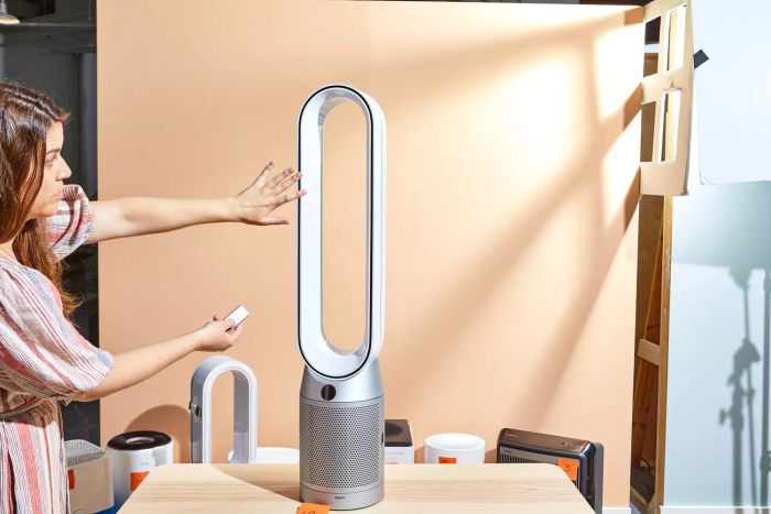 A person is seen holding a hand in front of the Dyson Purifier Cool Purifying Fan TP07.