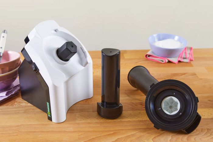 Parts of the Yonanas Classic Soft-Serve Dessert Maker displayed on a wooden table