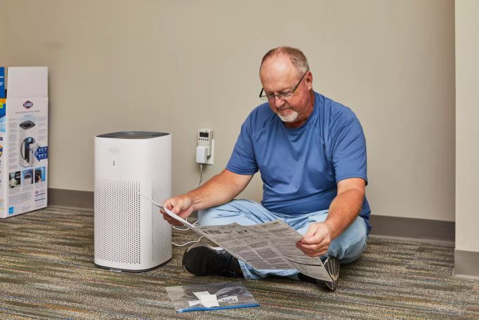 An individual reviewing the instructions for the Clorox Large Room True HEPA Air Purifier