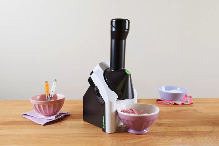 The Yonanas Classic Soft-Serve Dessert Maker shown with bowls on a wooden countertop