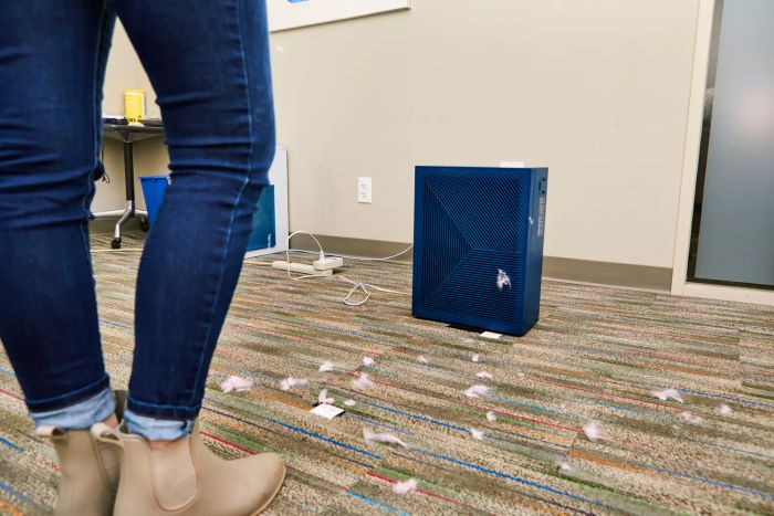 The Coway Airmega 160 Air Purifier placed on the floor, surrounded by dust