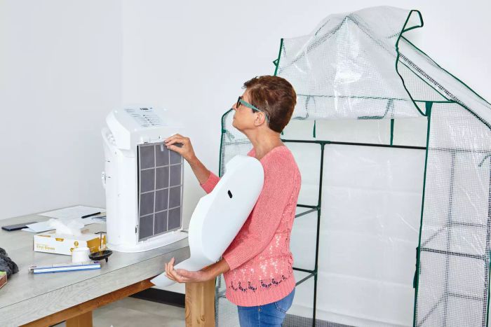 A person is seen removing the filter from the Rabbit Air BioGS 2.0 Ultra Quiet Air Purifier.