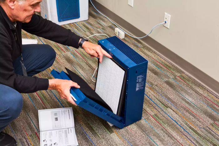 A person removing the filter from the Coway Airmega 160 Air Purifier