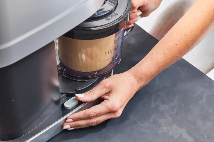 Close-up of hands holding the Ninja Creami Deluxe 11-in-1 XL Ice Cream Maker