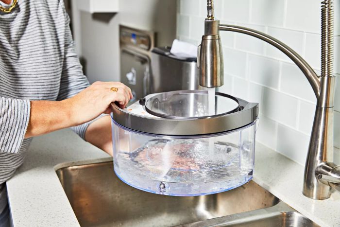 Hands pouring water into the reservoir of the Dyson Purifier Humidify+Cool Formaldehyde PH04.