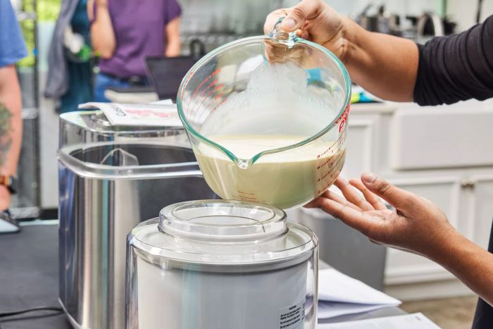 A person pours liquid ice cream base into the Cuisinart 1.5-Quart Frozen Yogurt, Ice Cream, & Sorbet Maker