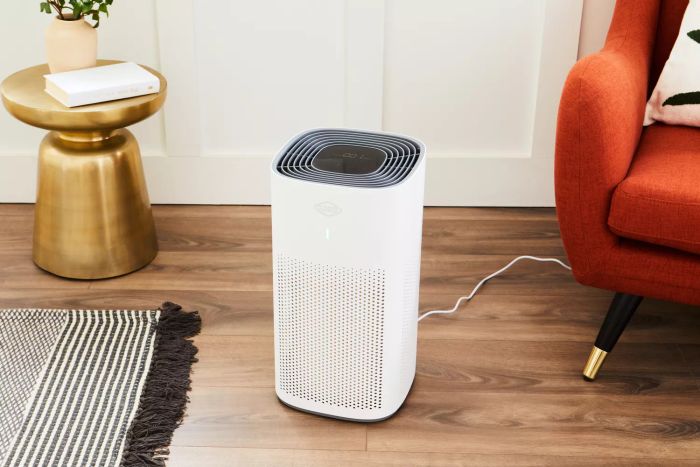 The Clorox Large Room True HEPA Air Purifier placed on a wooden floor in a cozy home environment
