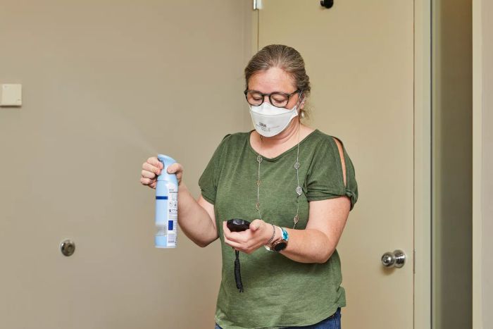 A person spraying room freshener while testing the Rabbit Air A3 Ultra Quiet HEPA Air Purifier.