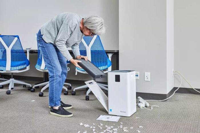 Someone removing the filter from the Kenmore 1500e Air Purifier