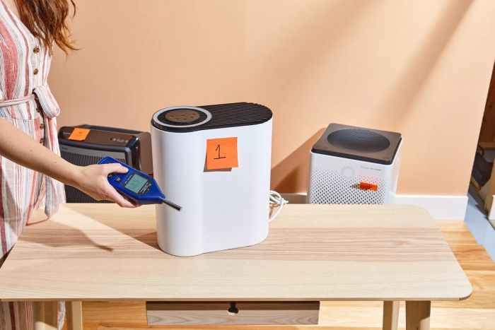 A person is seen taking a reading from the Aroeve MK04 Air Purifier.