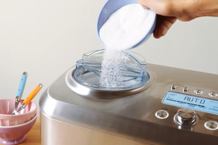 Hand adding sugar into the Breville The Smart Scoop Ice Cream Maker