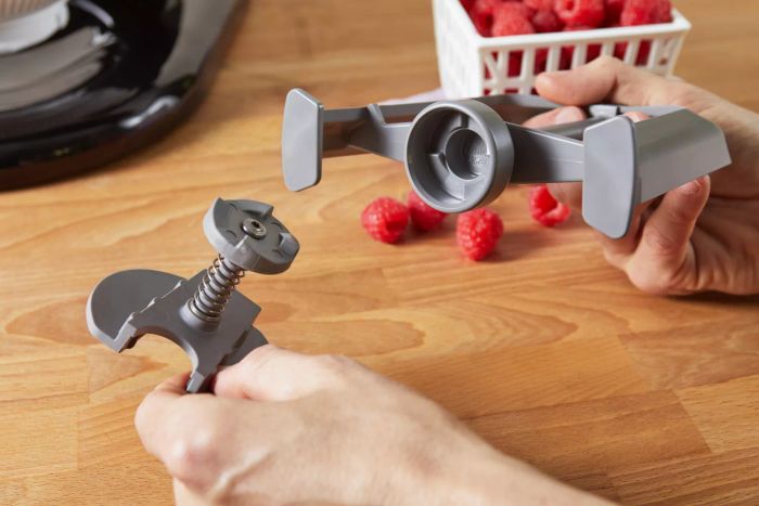 Hands holding the individual parts of the KitchenAid Ice Cream Maker Attachment