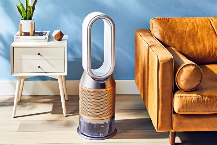 The Dyson Purifier Humidify+Cool Formaldehyde PH04 placed on a wooden floor beside a sofa.
