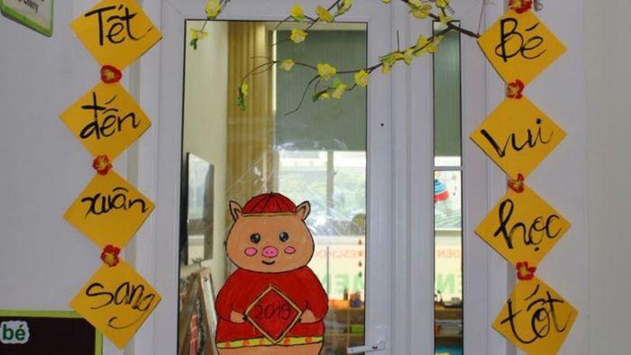 Trang trí cửa chính lớp mầm non với những biểu tượng Tết đặc trưng, mang đến không khí vui tươi và phấn khởi.