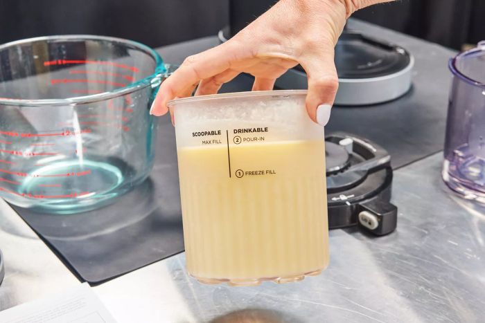 Hand holding the container for the Ninja Creami Deluxe 11-in-1 XL Ice Cream Maker
