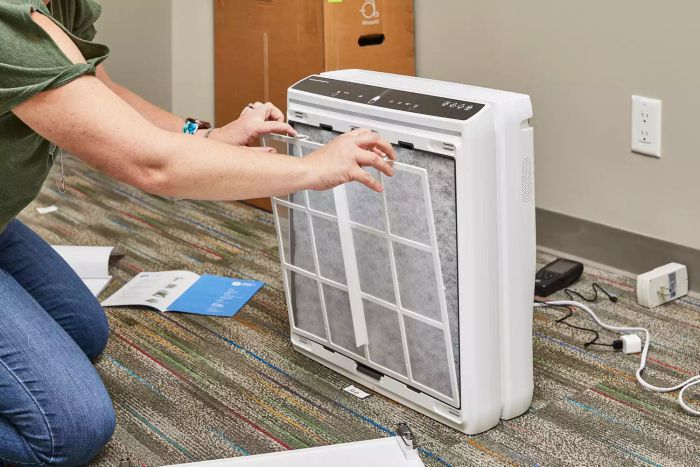 A person adjusting the Rabbit Air A3 Ultra Quiet HEPA Air Purifier.