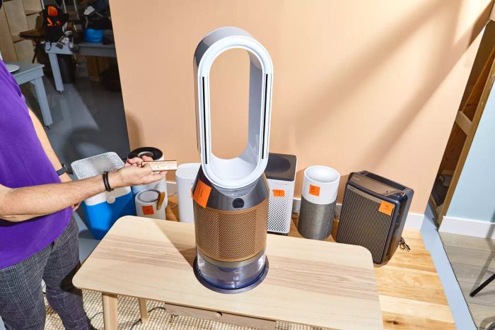 A person controlling the Dyson Purifier Humidify+Cool Formaldehyde PH04 with a remote.