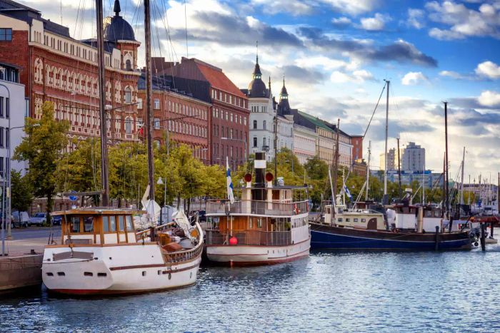 A stunning view of Helsinki, the capital of Finland, featuring the embankment with boats and houses at sunset, showcasing Northern Europe’s charm.
