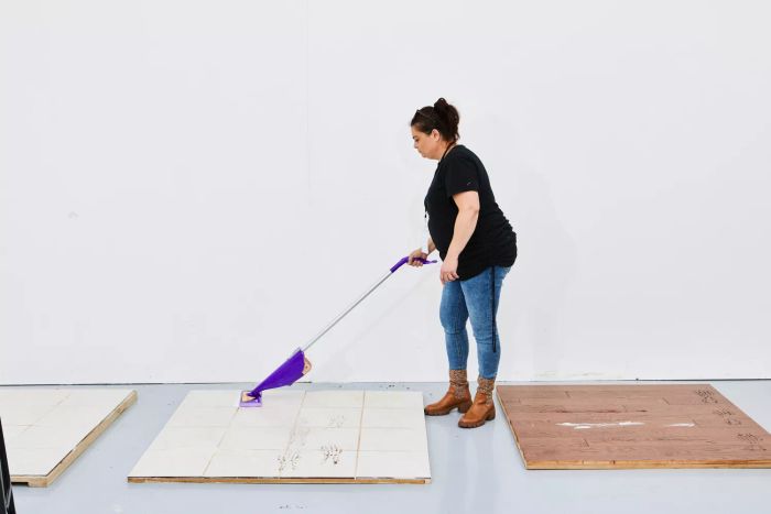 A person mopping a tile floor using the Swiffer WetJet.