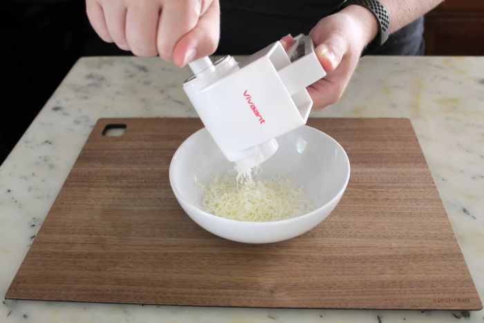 A person grating cheese into a bowl using the Vivant Rotary Grater