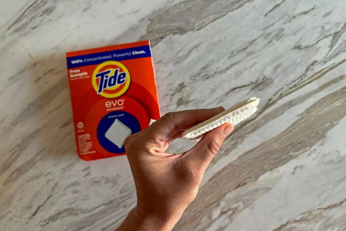 A person demonstrates the thickness of the Tide Evo Concentrated Detergent.