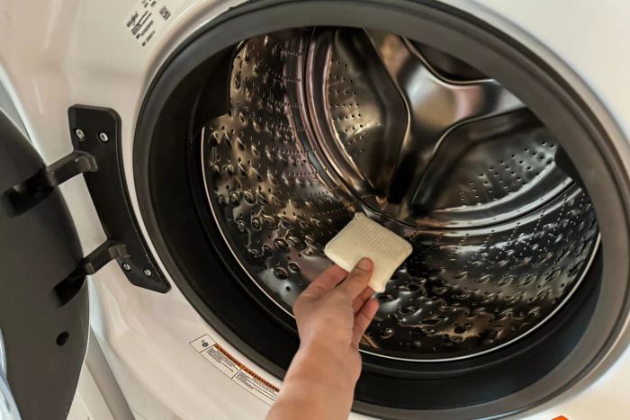 A person adds the Tide Evo Concentrated Detergent to a washing machine