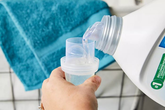 All Free Clear Liquid 2x Concentrated Laundry Detergent being poured into the measuring cap.