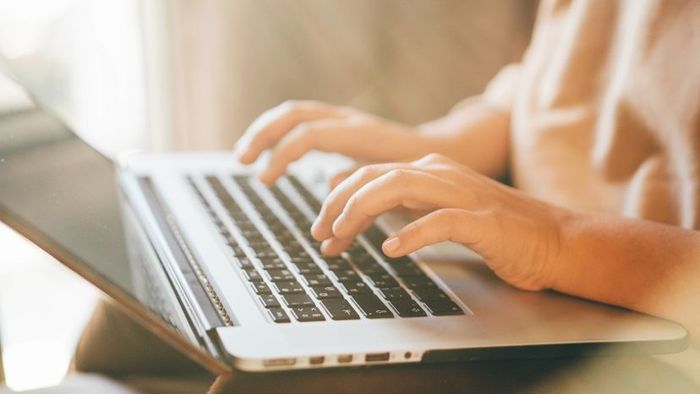 A woman typing on her laptop.