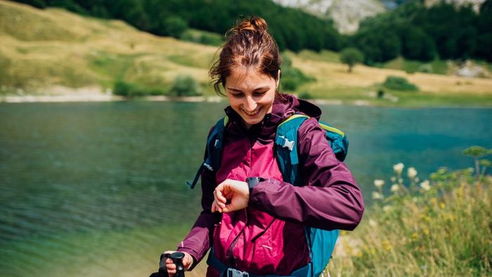 A female hiker checking her GPS watch.