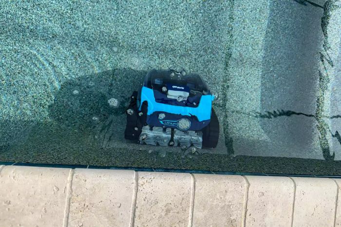 The Polaris Freedom Cordless Robotic Pool Cleaner in action, cleaning an in-ground pool.