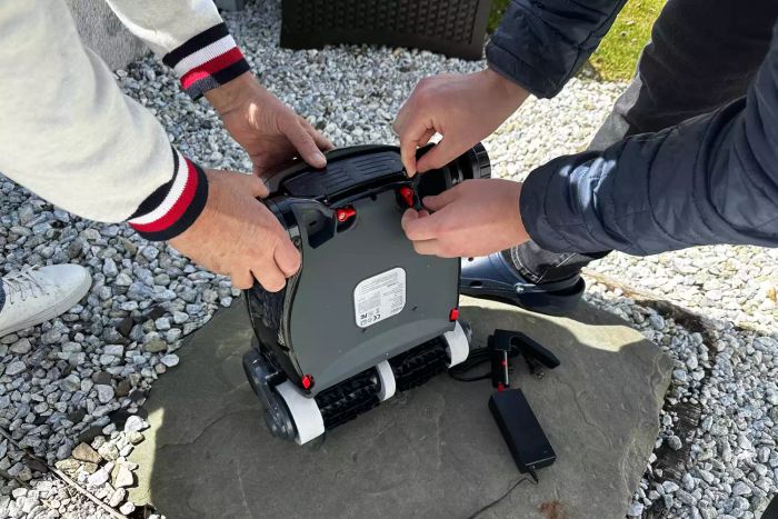 Two people assembling the Aiper Elite Pro Cordless Robotic Pool Cleaner together