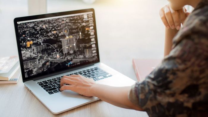 A woman using her laptop to navigate a map.