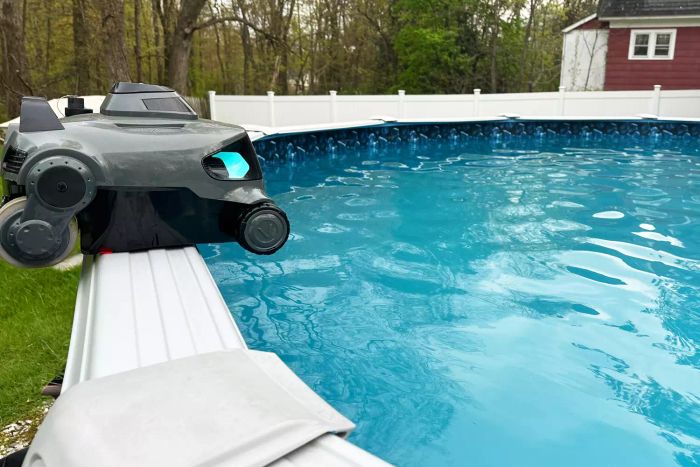 Aiper Elite Pro Cordless Robotic Pool Cleaner positioned at the edge of an above-ground pool