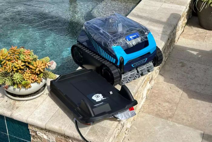 The Polaris Freedom Cordless Robotic Pool Cleaner positioned at the edge of a pool.