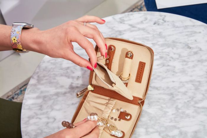 A person demonstrating the features of the Levenger Carrie Mini Jewelry Organizer