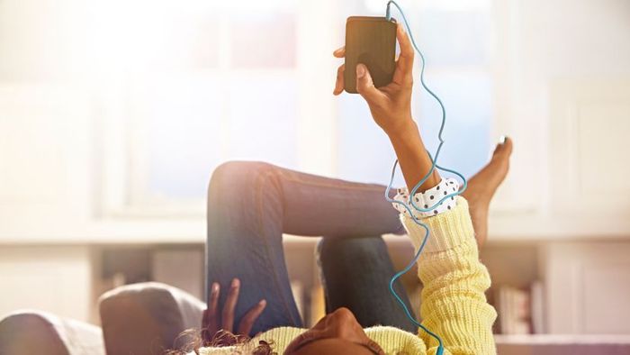 A young girl with an earpiece, immersed in her music.