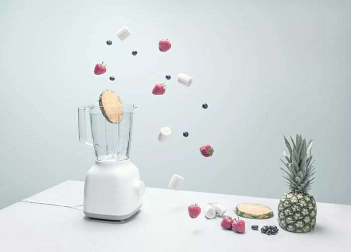 a blender filled with an assortment of fruits, vegetables, and coffee beans