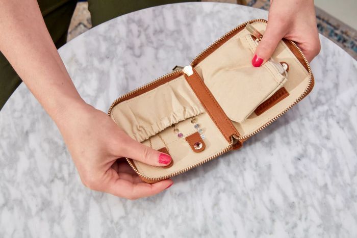A person demonstrating how the Levenger Carrie Mini Jewelry Organizer opens