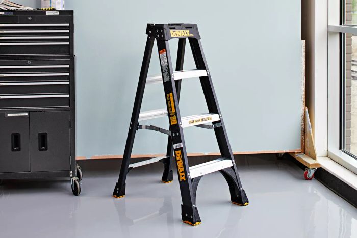 DeWalt 4-Foot Fiberglass Step Ladder positioned against a wall next to a window and a cabinet.