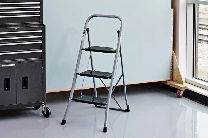 Delxo Step Stool Folding Step Ladder 3 Step displayed next to window and a cabinet
