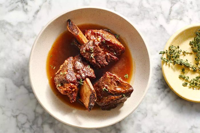 Braised Short Ribs served in a bowl with their braising liquid