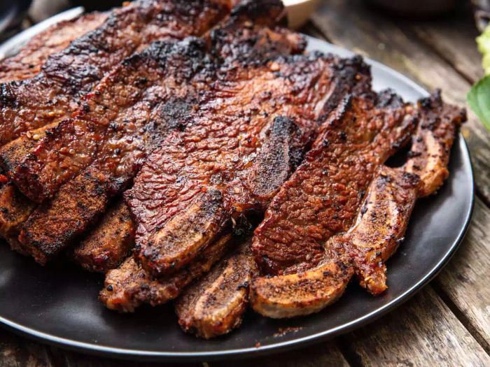 A closeup side view of a platter piled high with grilled galbi.