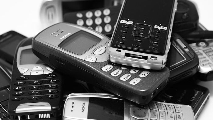 A collection of old smartphones and cell phones.