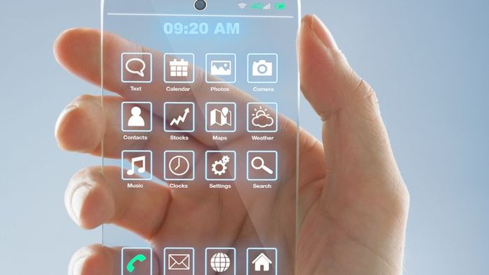 A person holding a see-through smartphone with various home screen apps displayed on it.