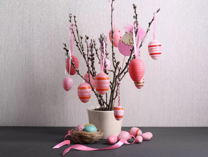 willow branches adorned with pink Easter eggs as part of holiday decor