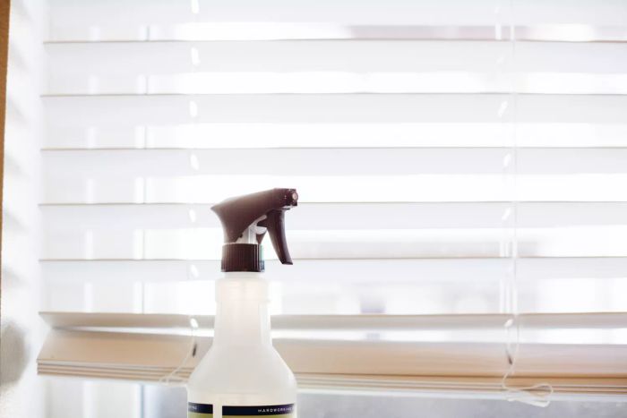 White blinds with a bottle of disinfectant spray