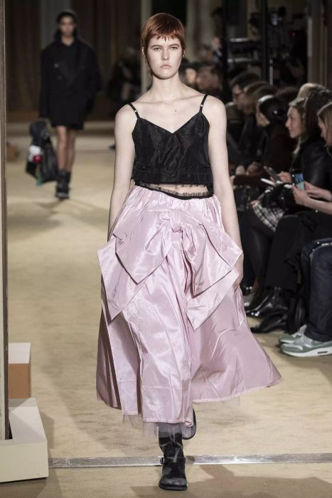 A model dazzles in a black tank top paired with a pink bow skirt at Coach’s runway show.